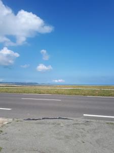 HirelRose by the sea - Beach front sea views的空空的机场跑道,有蓝天和云