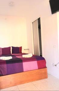 拉克鲁斯Regina Pacis (VALLE-LUZ)的一间卧室配有一张带彩色毯子的床