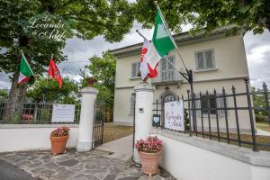 斯卡尔佩里亚La Locanda di Adele - Il Giardinetto B&B的栅栏前有旗帜的房子