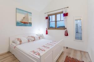 奥库格哥恩基Apartments Villa Kameja的白色的卧室设有白色的床和窗户。