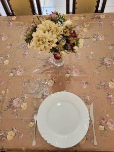 科伦巴Sobrado 4 amplo e confortável em condomínio的一张桌子,上面有盘子和一束鲜花