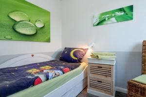 索尔陶Söhrenhof - Spechtschmiede的儿童卧室,配有一张床和一个床头柜