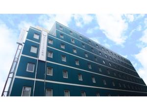 仙台Sendai Business Hotel Ekimae - Vacation STAY 71937v的一座高大的蓝色建筑,背后是天空