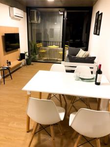 罗萨里奥Cilveti 468 departamento con cochera, excelente ubicación的客厅配有白色的桌椅