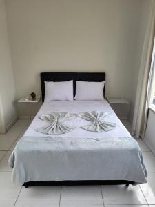 科伦巴Sobrado 4 amplo e confortável em condomínio的一间卧室配有一张带白色床单的大床