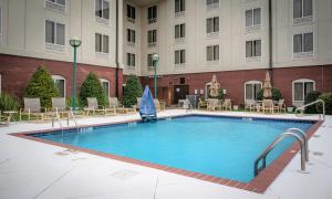 塔斯卡卢萨Holiday Inn Express & Suites - Tuscaloosa-University, an IHG Hotel的酒店的大型游泳池配有桌椅