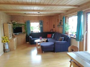 蒂蒂湖-新城Sommerruhe的客厅配有蓝色的沙发和桌子