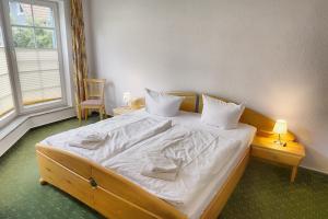 青斯特An der Galerie, A 08的卧室配有一张带白色床单和枕头的大床。