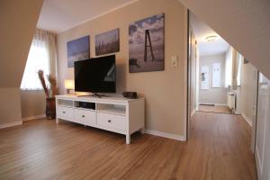 斯匹科罗格Dörphuus Wohnung Dorfblick的客厅配有白色橱柜上的平面电视
