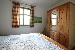 欧巴德伍斯图Strandlöper的一间卧室配有一张床和一个木制橱柜