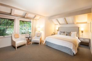 圣海伦娜丰收酒店的一间卧室配有一张床、两把椅子和一个窗户