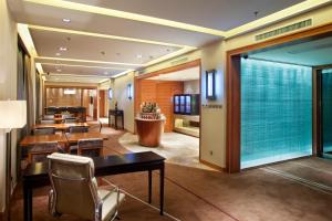牡丹江牡丹江世茂假日酒店的餐厅设有桌椅和大窗户。