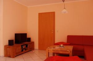 卡尔斯哈根Pepes Ferienwohnung的客厅配有红色沙发和电视