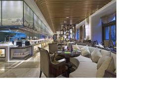 天津天津万达文华酒店的餐厅配有沙发和桌椅