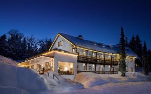 施瓦岑贝格Alpenhotel Bödele - Luxus Suite 01的夜晚雪中的一个白色大房子