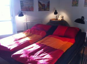 霍森斯Bed & Breakfast Horsens - Udsigten的一张床上有五颜六色的毯子,放在房间里
