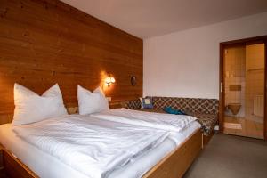 奥贝劳Christof,s Ferienwohnung WILD230的一间卧室设有一张带木墙的大床