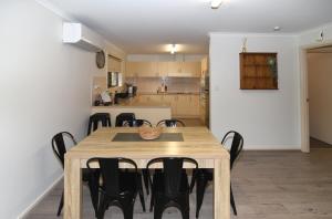 塔南达Tanunda's Magpie House的用餐室以及带木桌和椅子的厨房