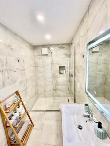 地拉那Central Studio Apartment 1, Tirana的浴室配有白色水槽和淋浴。
