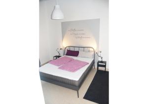 Perticarada Marianna的白色卧室配有带粉红色床单的床