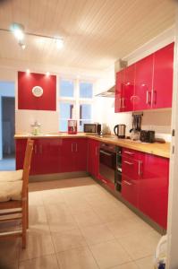 海利根港Fischerhaus am Binnensee的一间厨房,配有红色橱柜和台面