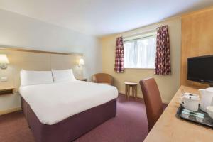 温彻斯特戴斯温切斯特酒店的酒店客房设有一张大床和一张书桌。