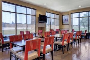 琼斯伯勒Comfort Suites Jonesboro University Area的用餐室设有桌椅和窗户。