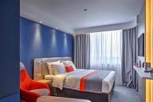 阿拉木图Holiday Inn Express - Almaty, an IHG Hotel的配有一张床和一把椅子的酒店客房
