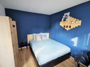 朗斯Chez Jo的蓝色的卧室,配有床和蓝色的墙壁