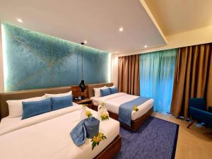 长滩岛Fairways and Bluewater Boracay的酒店客房设有两张床和蓝色的墙壁。