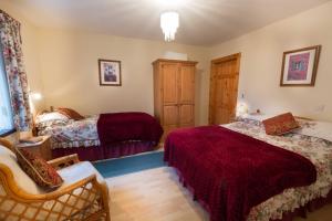 卡瑞克福格斯Drumgart Self Catering Cottage的一间卧室配有两张床和一把椅子。