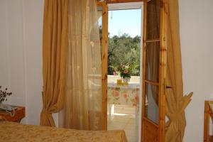 圣马太奥斯Prasoudopetra的一间卧室设有一扇门,可通往带窗户的房间
