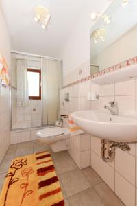 尼布卢姆Schleswig-Holstein Whg 02 EG re的白色的浴室设有水槽和卫生间。