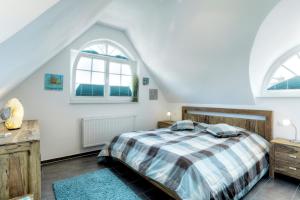 青斯特Villa Obendtied, DG-Wohnung "Reet" FW 6的一间卧室设有一张床和两个窗户。