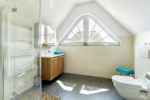 青斯特Villa Obendtied, DG-Wohnung "Reet" FW 6的一间带卫生间、水槽和窗户的浴室