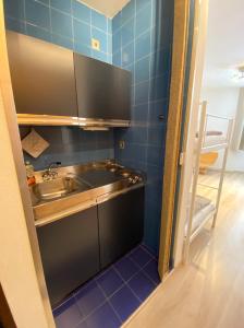 阿贝托内Residence Foemina 65 Val di Luce的小厨房配有水槽和蓝色瓷砖