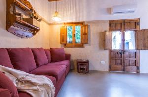 埃尔博斯克Encantadora casa rural con piscina privada的客厅配有紫色沙发和桌子
