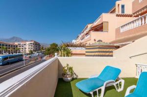 洛斯克里斯蒂亚诺斯Apartament 1 bedroom Los Cristianos Las Vistas beach的阳台配有蓝色椅子,享有街道的景色
