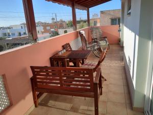 XylophaghouLarnaca Xylophagou 2-bedroom apartment with a shaded terrace的阳台配有两把椅子、一张桌子和一辆自行车