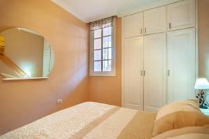 洛斯克里斯蒂亚诺斯Apartament 1 bedroom Los Cristianos Las Vistas beach的一间卧室配有一张床和镜子