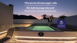 伊斯基亚Ischia Mavilan Luxury Apartments的带有标志的建筑物内的游泳池
