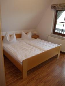 马尔洛Finnhäuser am Vogelpark - Haus Annika的一张带白色床单和枕头的床