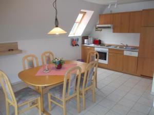 马尔洛Finnhäuser am Vogelpark - Haus Annika的厨房配有木桌、椅子和水槽