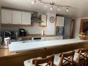 梅明根阿尔高公寓式酒店的厨房配有白色橱柜和白色台面