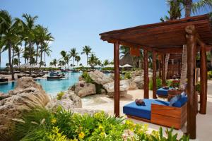 普拉亚卡门Secrets Maroma Beach Riviera Cancun - Adults only的度假村的游泳池,设有蓝色椅子和凉亭