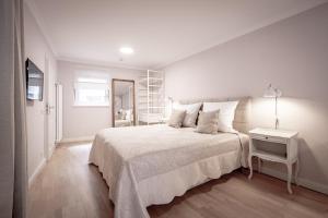 巴登-巴登Boutique Charme Apartments的白色卧室配有一张大床和一张桌子
