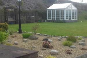 多尼戈尔Drumgowan House的后院带温室的花园