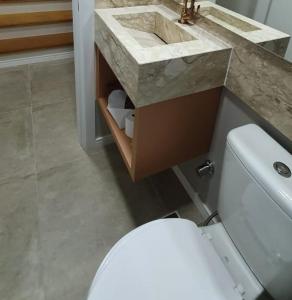 卡内拉Casa Nova Canela Condominio Fechado 40的浴室配有白色卫生间和盥洗盆。