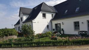 DunsumDeichhof Whg 26的黑色屋顶的白色房子
