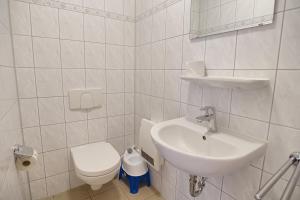 青斯特Am Deich 32的白色的浴室设有水槽和卫生间。